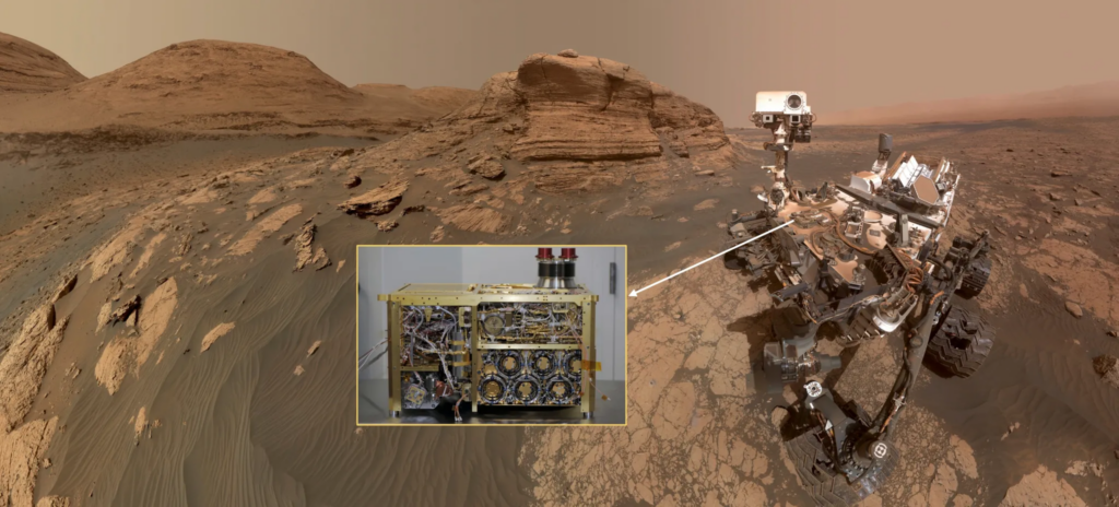 “Selfie” of the Curiosity rover with inset showing the SAM instrument prior to installation on the rover. In this image, the rover is in front of Mount Mercou, a 19.7-foot (6-meter) tall outcrop, and next to the “Nontron” sampling site. This area is in the transition region between the “clay-bearing unit” that the rover has finished exploring and the “sulfate-bearing unit” that the rover is now exploring.