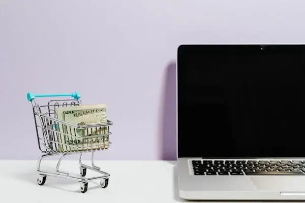 Shopping trolley beside laptop
