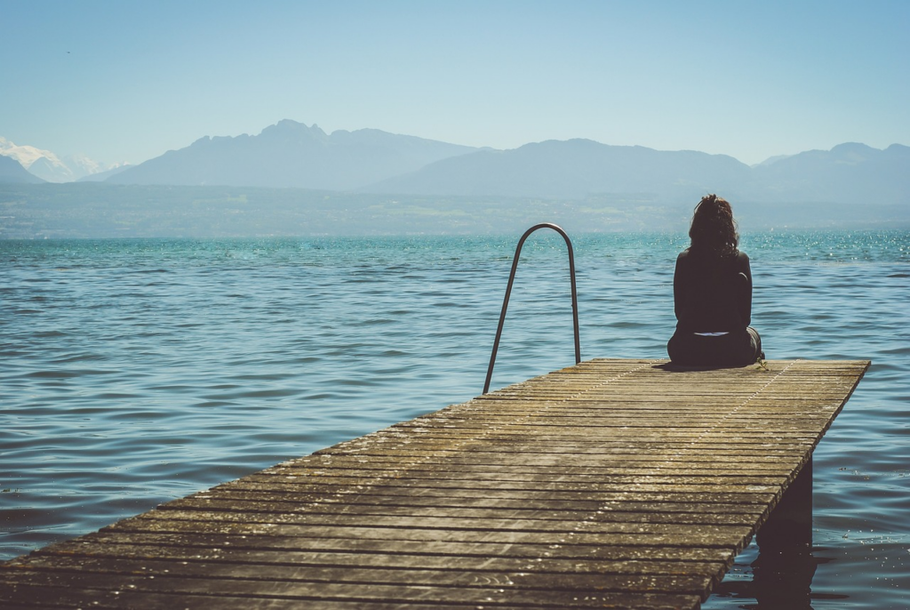 Woman sitting alone on a dock