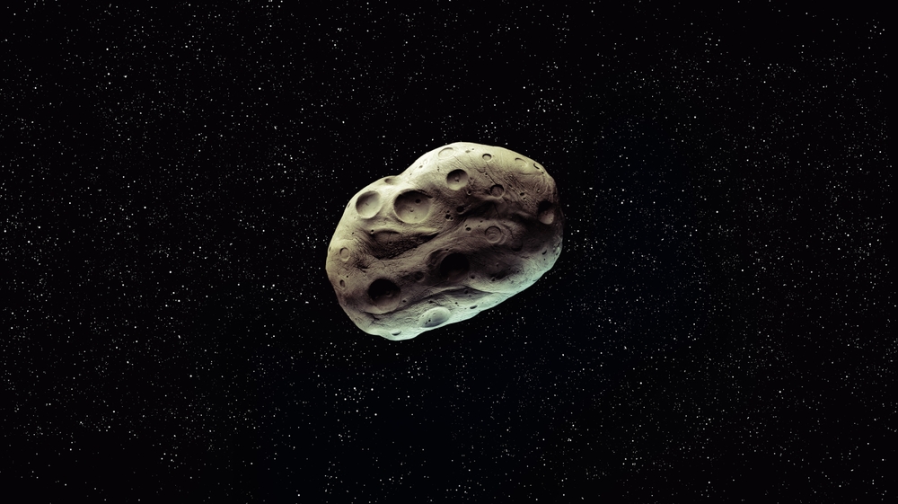 Asteroid with craters in outer space, surface of the space rock. Meteorite on a black background.