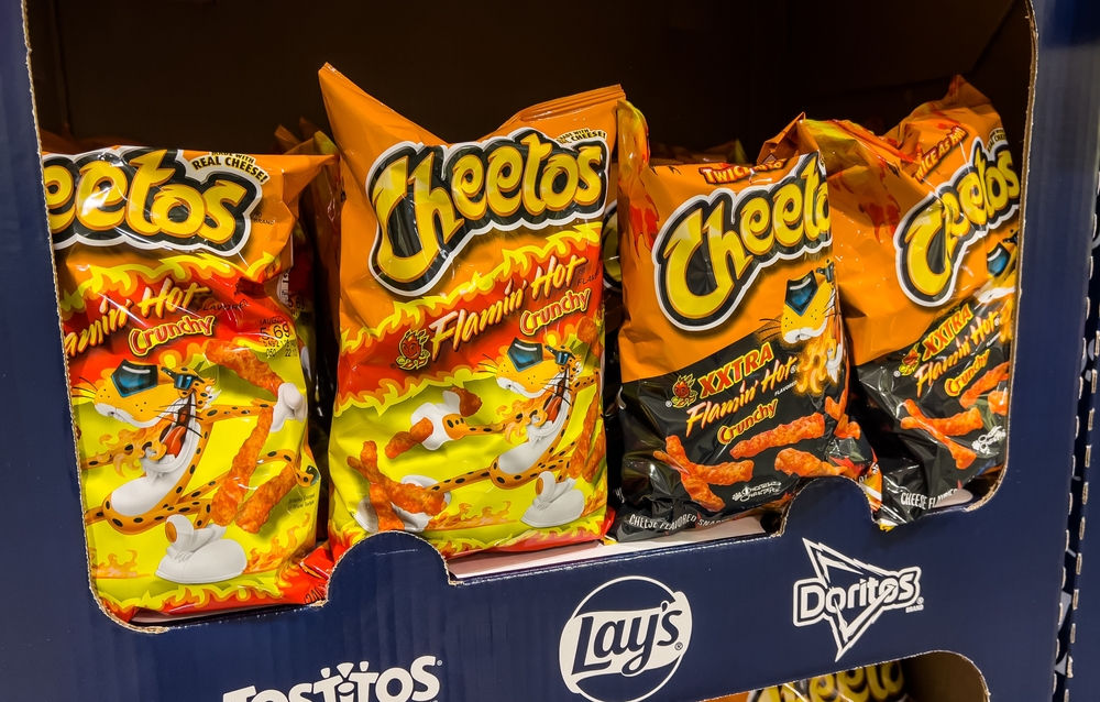 Los Angeles, CA, USA June 18 2023 Bags of Cheetos Flamin' hot brand cheese corn puffs snacks for sale at a supermarket shelf
