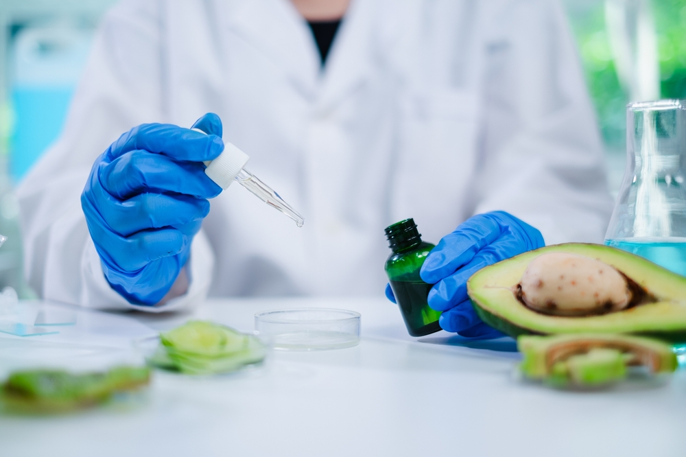 Close up of scientist drop avocado oil in cosmetic, skin care, essence and treatment laboratory. Concept of Serum, gel or cream essential experiment, learning and study the quality and developing.