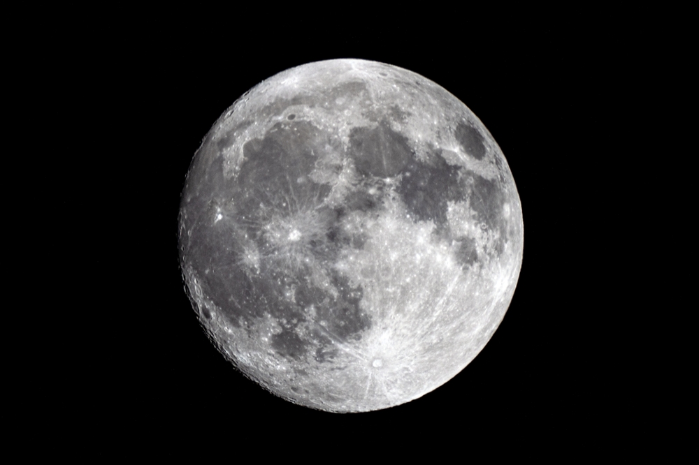 A high-resolution photograph of the full moon, capturing the intricate details of its surface against the dark night sky.