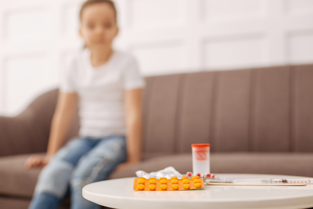 Adorable little patient looking at the whole bunch of pills