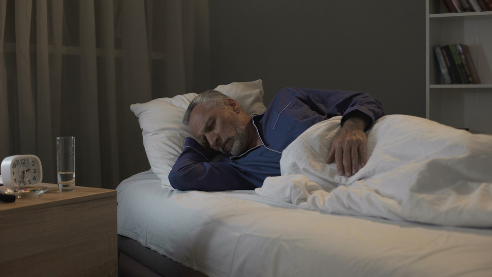 Retired man seeing nightmares in his dreams, sleeping in ward of nursing home