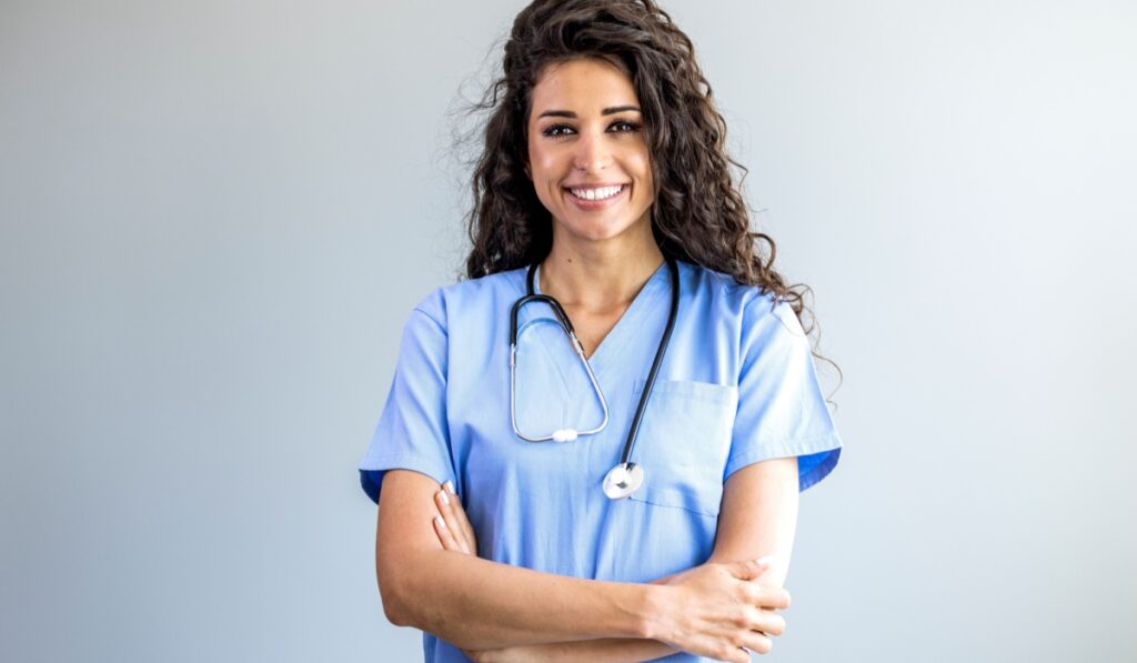 Portrait of a young nurse - doctor. Smiling Argentinian female nurse in medical scrubs. Shot of a female nurse standing confidently with her arms crossed. Portrait of female nurse at hospital