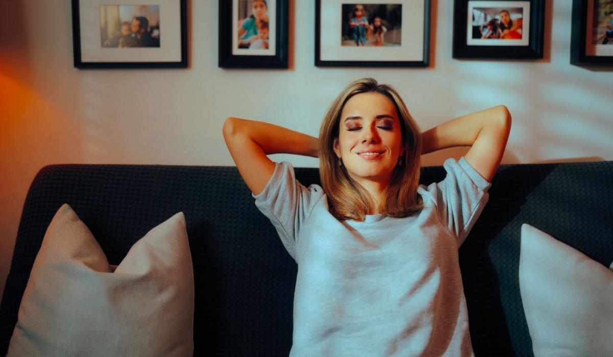 Happy Carefree Woman Sitting on a Sofa at Home Mother getting some alone time finally in silence