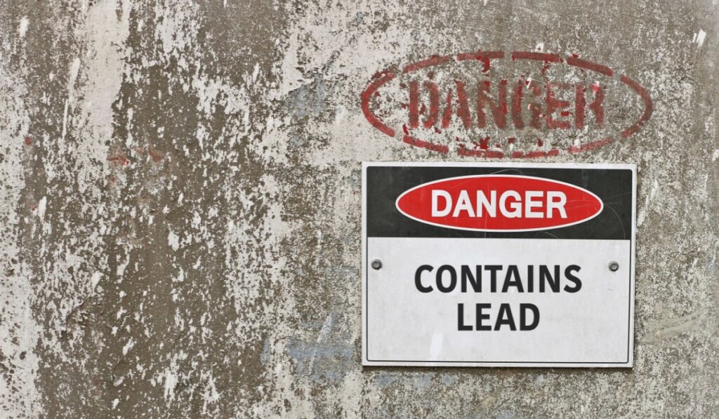 red, black and white Danger, Contains Lead warning sign