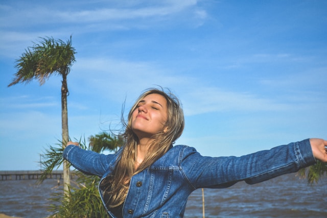 a woman by the coast, with hair flowing in the wind 