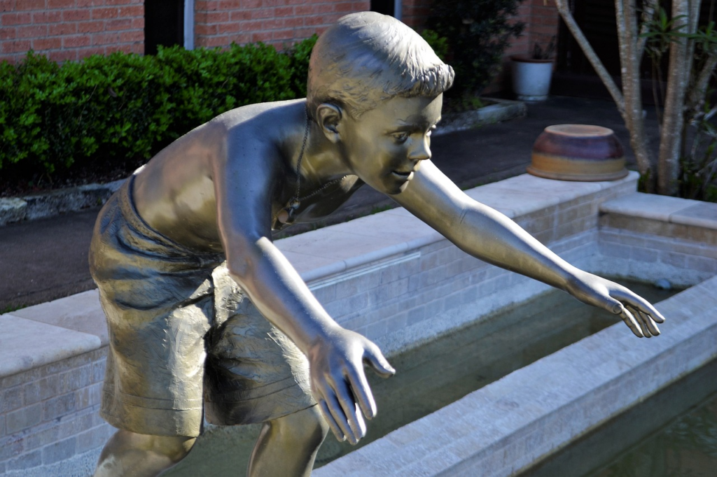 statue of a boy bent at the waist