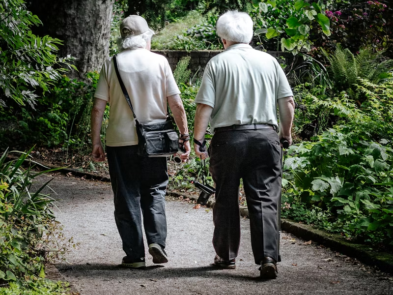 two seniors walking down a path