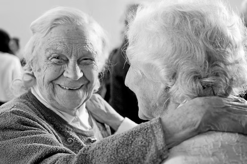 Two senior woman holding each other and smiling