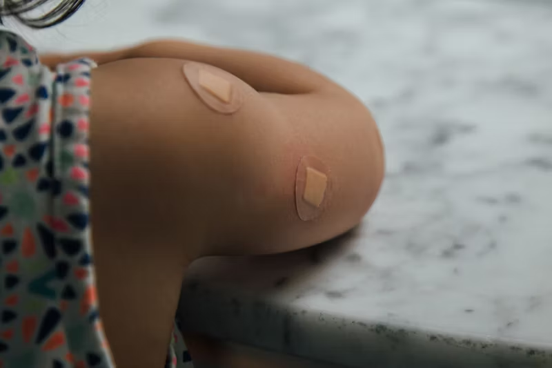 small child with vaccination bandaids