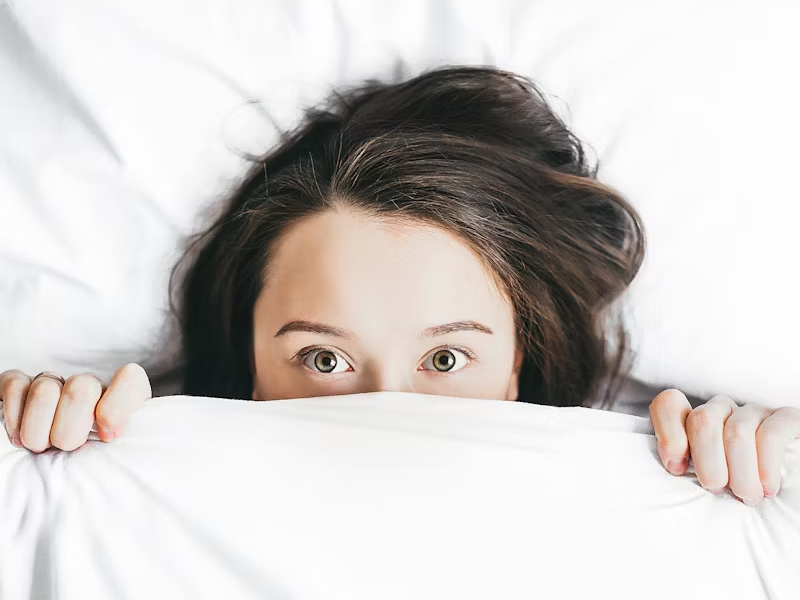 Person in their bed with eyes wide open