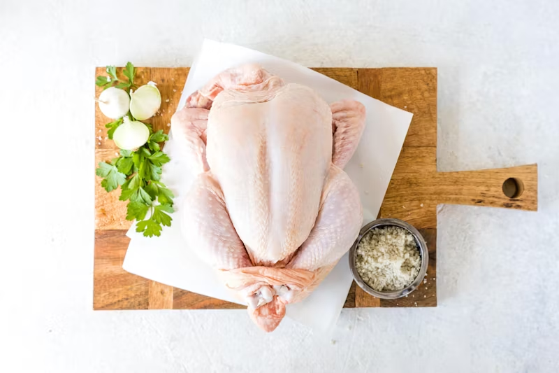 full raw chicken on a cutting board