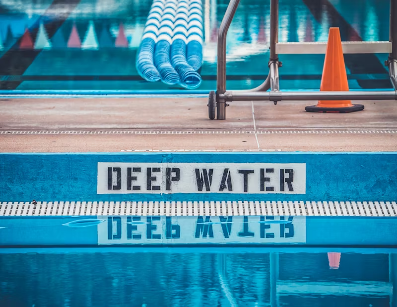 pool with "DEEP WATER" sign beside it