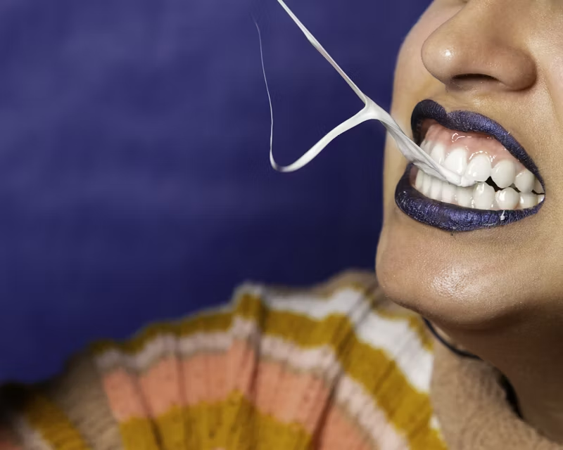 chewed gum being pulled from someones teeth