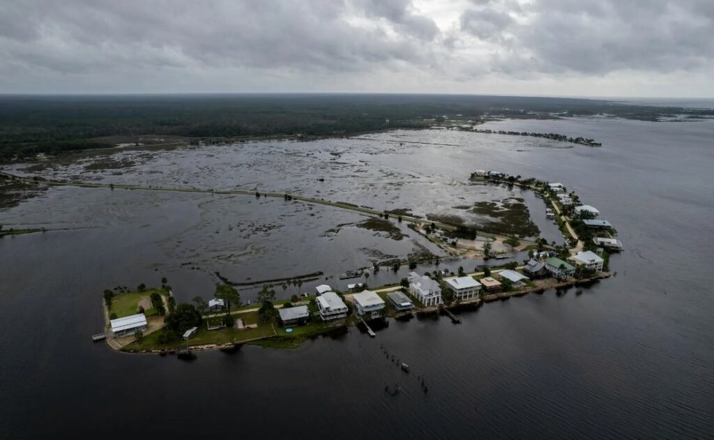 A row of houses covered in water off the coast. 
