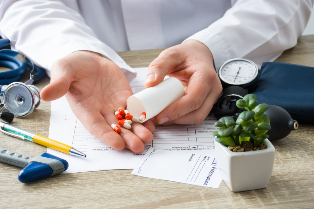 At doctors appointment physician shows patient capsules, which emptied into hand from container with focus on hand with drugs. Scene of prescription generic or OTC medications by doctor on visit