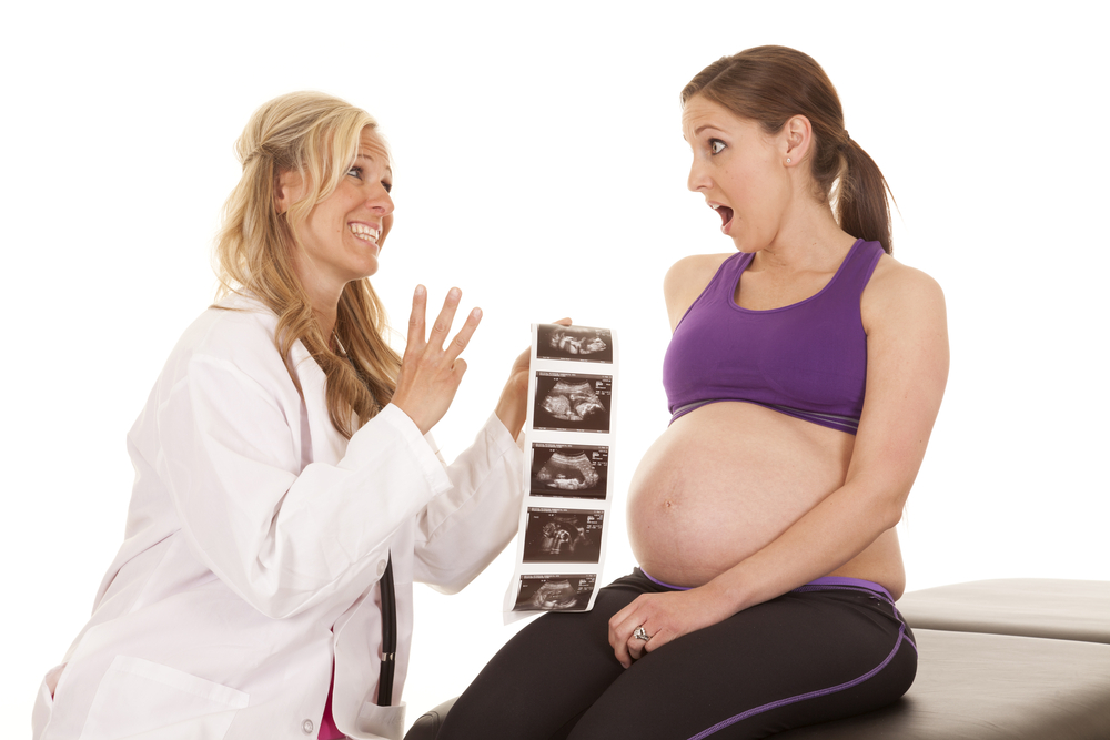 a doctor showing her pregnant patient that she is going to have triplets.