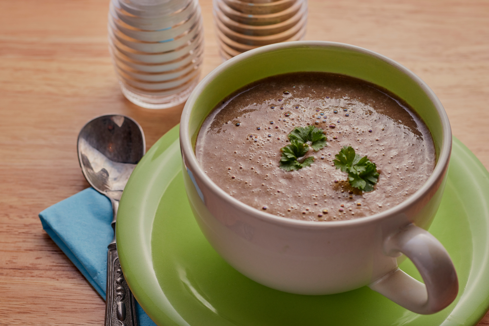 Mushroom soup shot close up on a wooden table.
