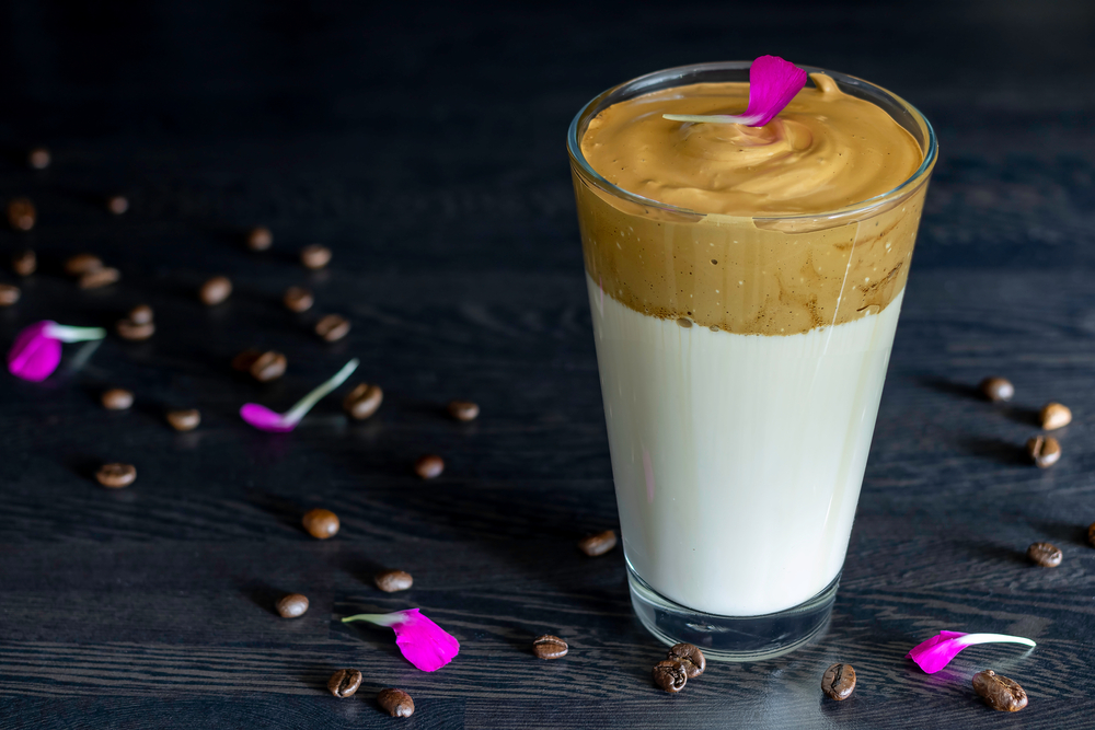 Dalgona coffee decorated with carnation flakes and coffee beans
