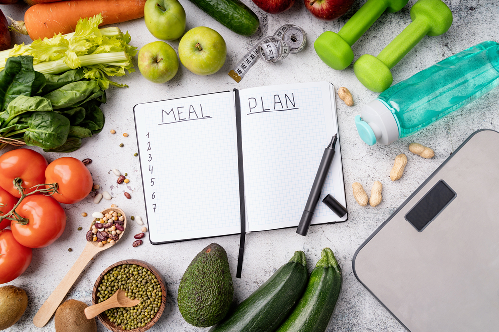 Notepad with words Meal Plan with healthy foods and sport equipment
