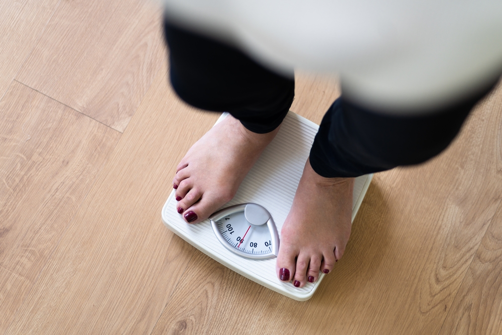 Low Section Of A Person Standing On Weighing Scale
