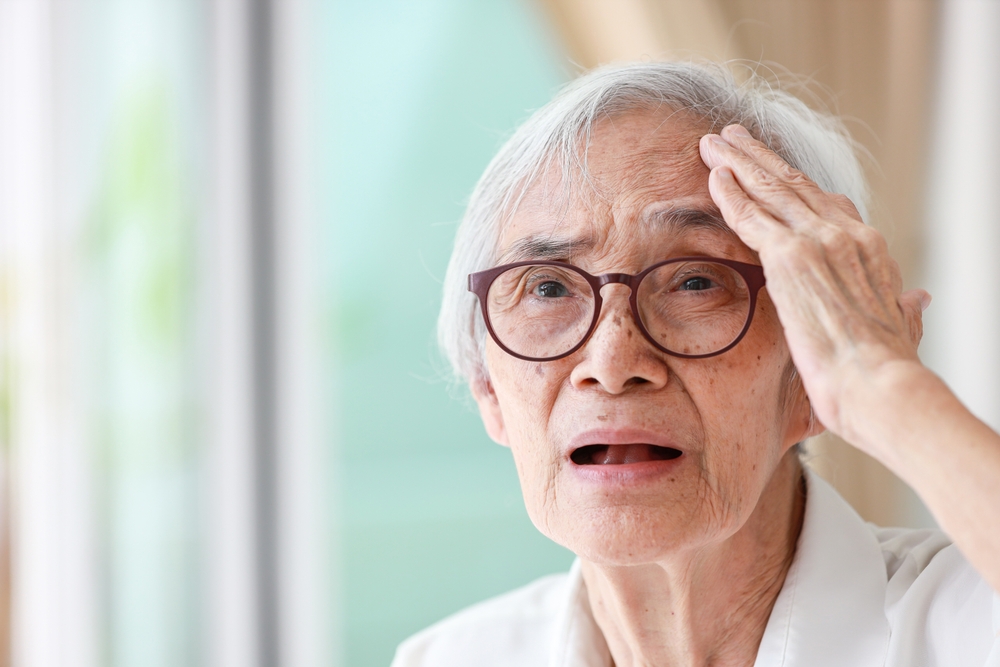 Forgetful asian senior woman with amnesia,brain disease,patient holding head with her hand,suffering from senile dementia,memory disorders,confused old elderly with Alzheimer's disease,health problems
