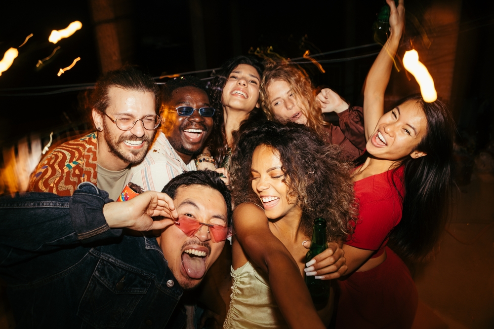 A group of multiracial friends has a great time at the roof nightclub in the summertime. Clubbing, fun, and parties during the summer concept.