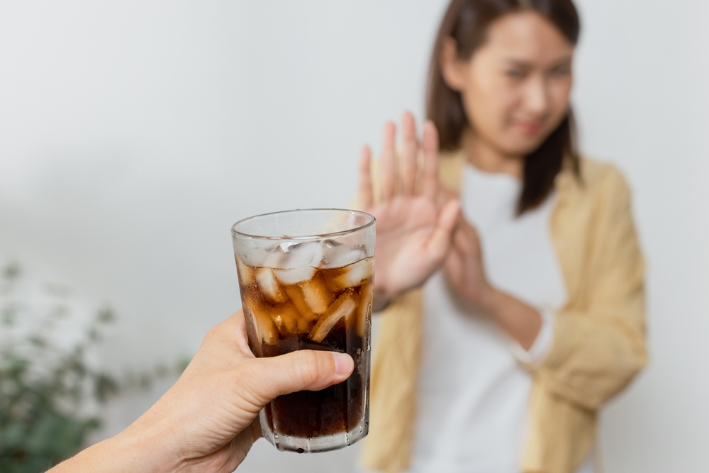 Close up sweet drink, Dieting healthy concept, lose weight, healthy diet, Choosing good food for health benefits. food unhealthy. hand holding glass of black water. female reject drink sugar.
