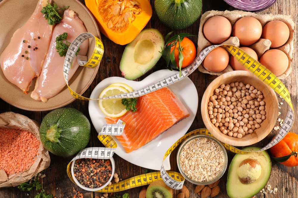 diet food concept- healthy fod selection with protein (chicken fillet,egg and salmon fish), fruit, vegetablea nd meter tape