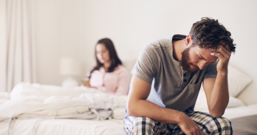 Angry couple, argument and fight on bed in disagreement, conflict or toxic relationship at home. Upset and frustrated man and woman fighting, breakup or divorce from affair or infertility in bedroom
