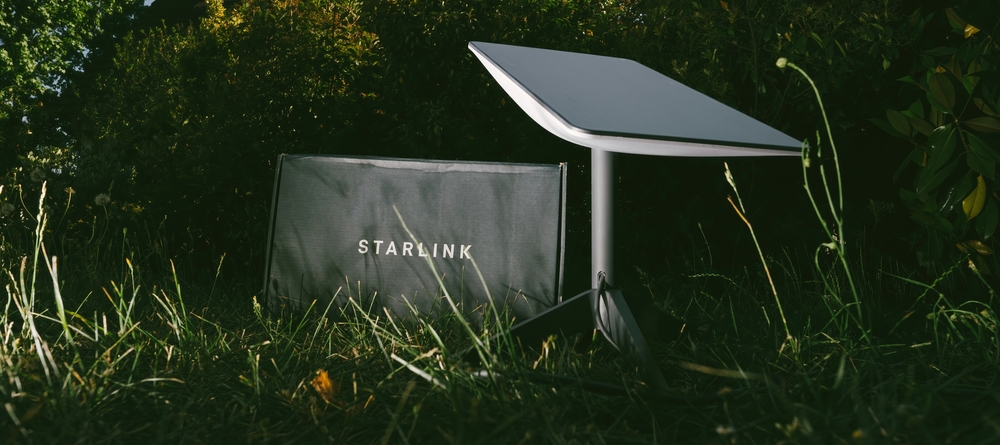 Germany - Jun 16, 2023: Cardboard parcel in backyard at night. Flash photography, no people. Is it a SpaceX Starlink delivery, setting up communication anywhere, even in wilderness spots

