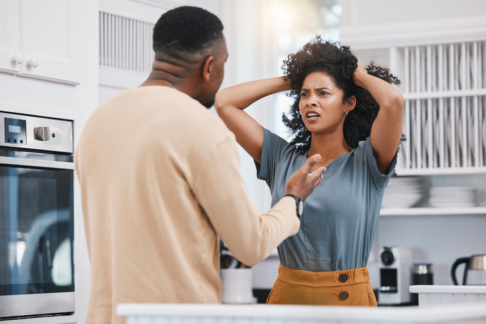 Stress, divorce and couple fighting in a kitchen with anxiety, debt or erectile dysfunction at home. Marriage, doubt and man with woman in a house for conflict, argue or liar, cheating or infertility
