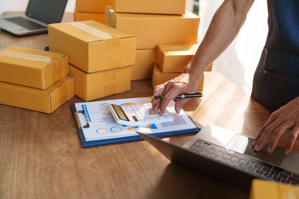 Thriving small businesses, often run by male freelancers, entrepreneurs, leverage e-commerce and logistics for online orders. home offices, manage packaging, shipping, client relations using laptops.