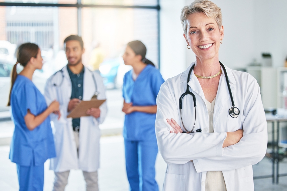Woman, doctor and portrait with arms crossed in hospital, clinic and leadership of surgery team. Cardiology, surgeon and consulting person with trust in advice of expert, service and healthcare
