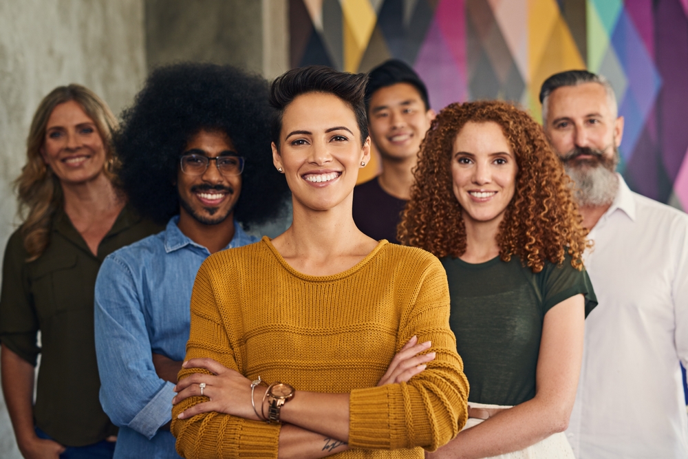 Arms crossed, smile and portrait of employee, group and creativity of writer, female leader and startup. Happy, team and diversity in business, face and people with confidence, together and editor
