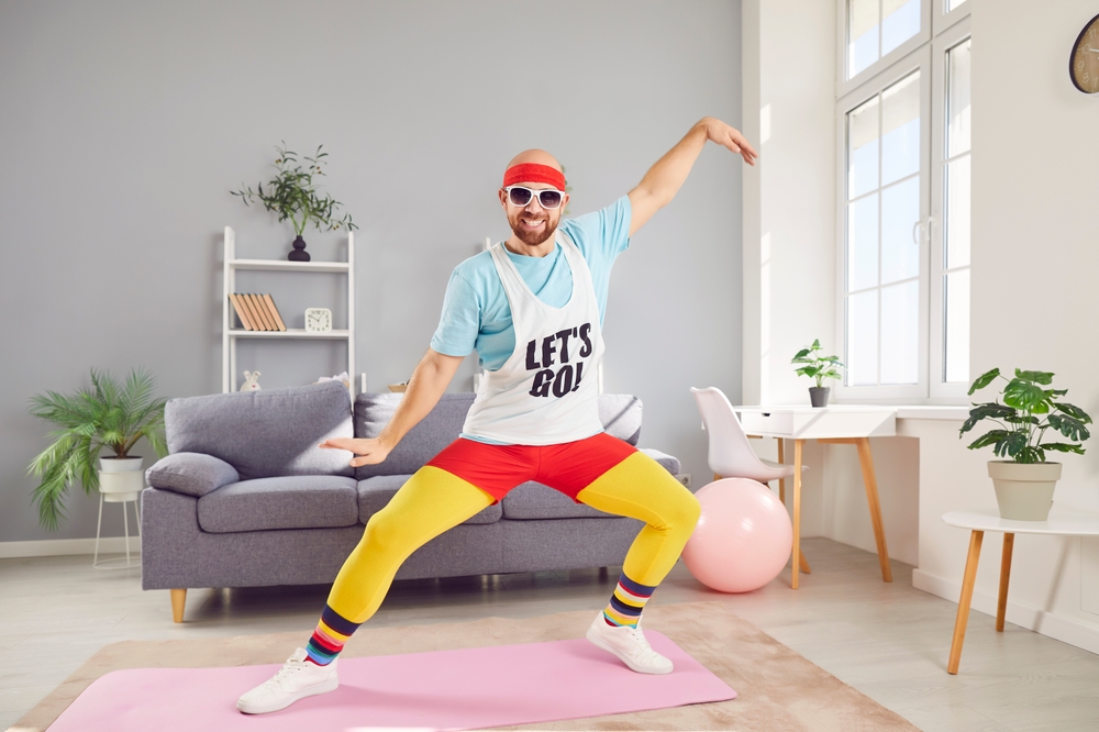 Funny man dancing or doing an sport exercise during workout at home gym. His lighthearted approach to fitness adds a fun element to training, showcasing commitment to staying active and healthy.