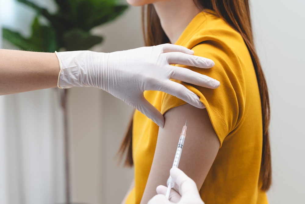 People getting a vaccination to prevent pandemic concept. Woman in medical face mask receiving a dose of immunization coronavirus vaccine from a nurse at the medical center hospital