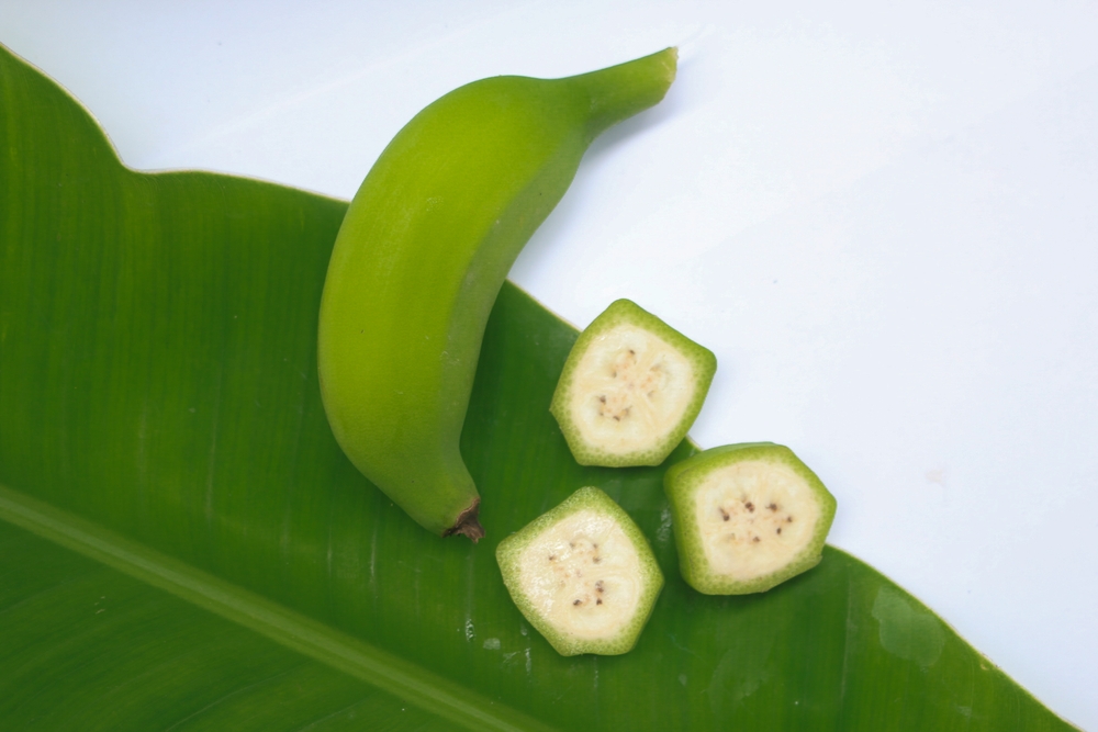 Top view, raw banana with green banana leaves Align to the left To have free space. Sliced bananas. Nutritional concepts, high nutrients, properties, benefits of raw bananas.