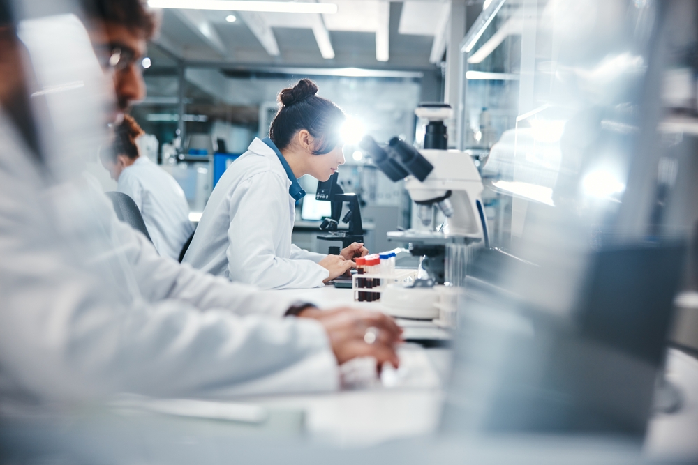Medical, research and scientist in laboratory with microscope, observation and experiment for study. Healthcare, employees or doctor with machine for examine cells, microorganisms and investigation
