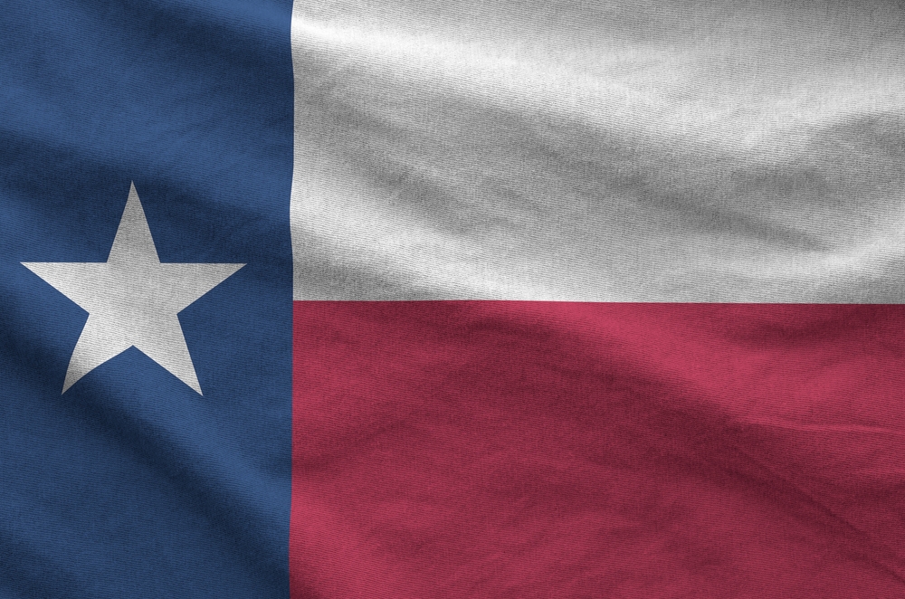 Texas US state flag depicted on folded wavy fabric of old cloth close up
