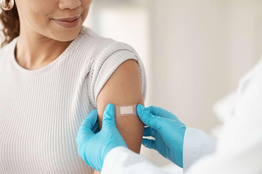 Vaccine, happy woman and hands of doctor with plaster for health, wellness and service in clinic. Healthcare, patient and expert in hospital for immune system strength, illness prevention or flu shot
