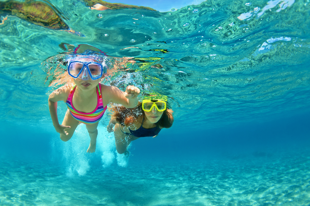 Happy family - mother with baby girl dive underwater with fun in sea pool. Healthy lifestyle, active parent, people water sport outdoor adventure, swimming lessons on beach summer holidays with child
