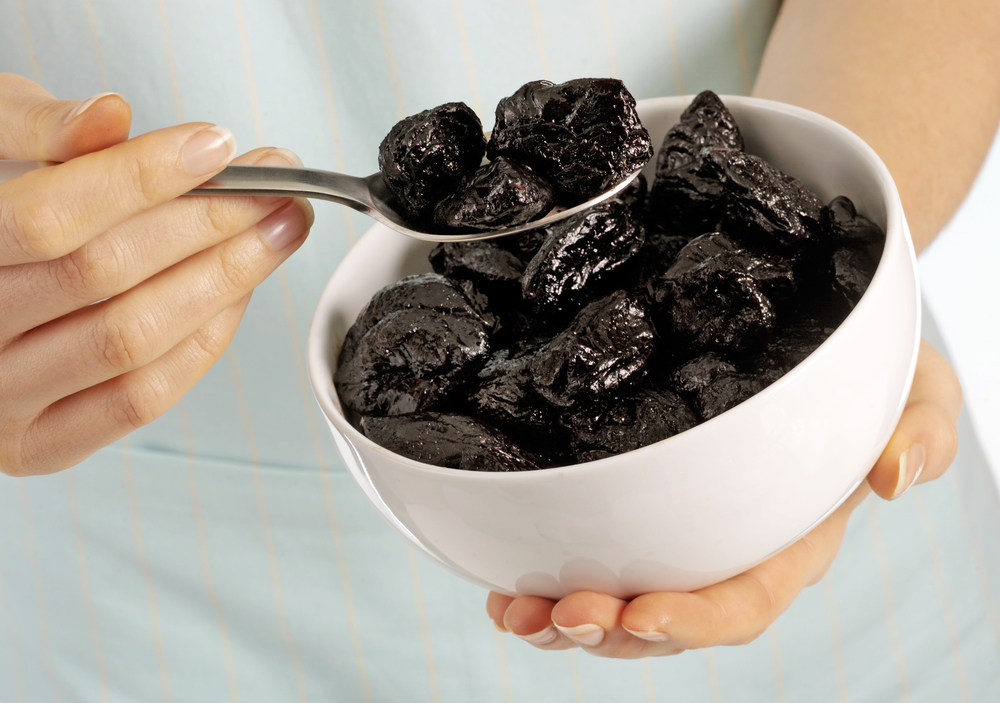 WOMAN EATING PRUNES
