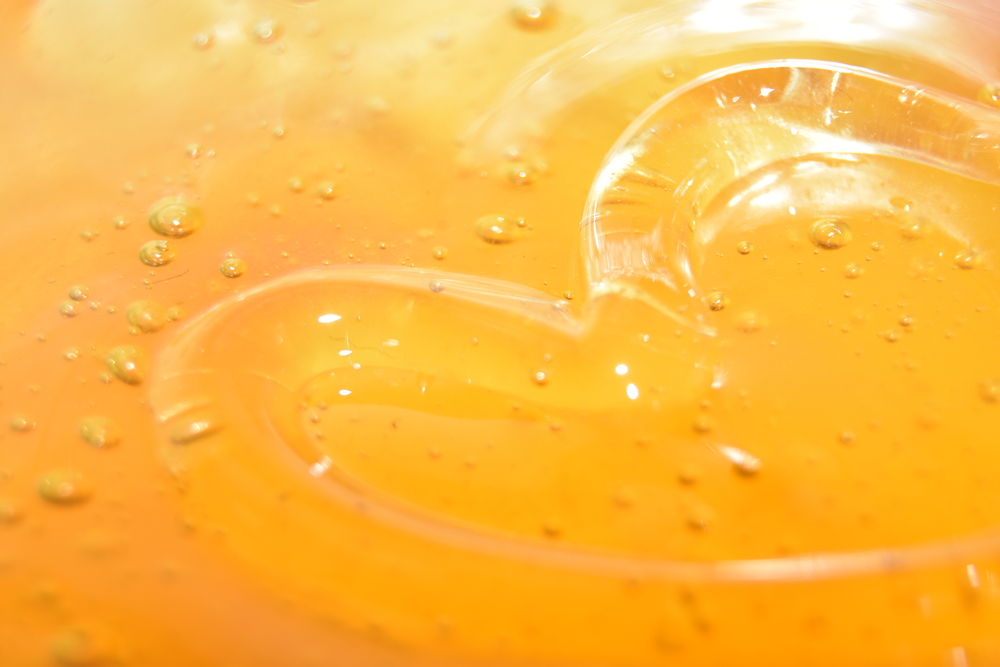 Background texture in a bowl with honey painted heart honey inside with air bubbles