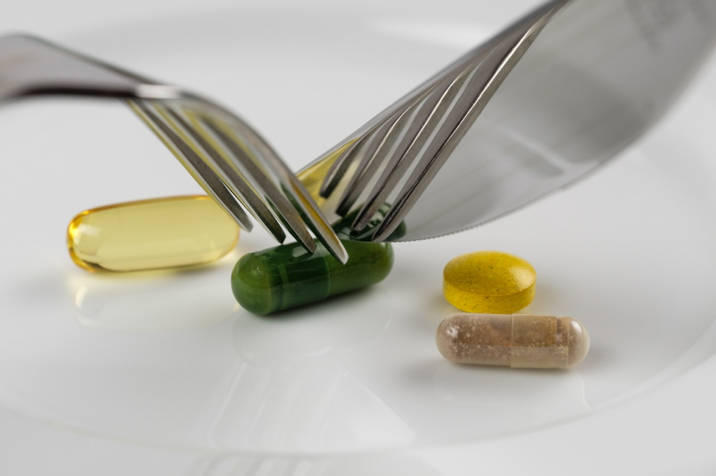 a vitamin being handled with a knife and fork