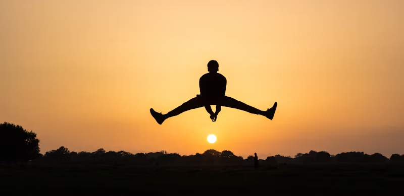 silhouette hopping over the sun