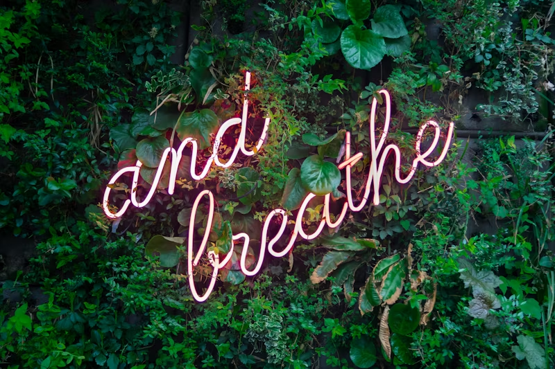 Neon sign reading "and breathe"